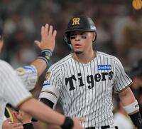４回、ソロを放ちベンチ前で迎えられる佐藤輝（撮影・西田忠信）