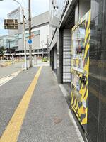 広島駅（奥）近くに設置されている阪神グッズの自販機（右）