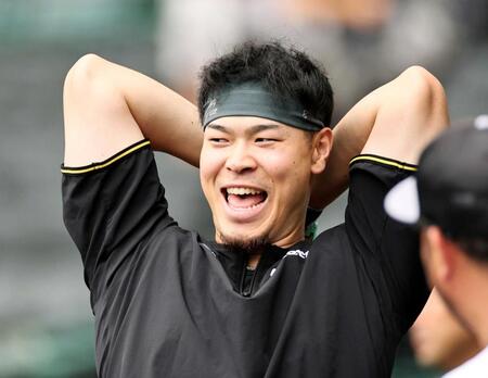 　打撃練習を待つ間、笑顔を見せる佐藤輝（撮影・田中太一）