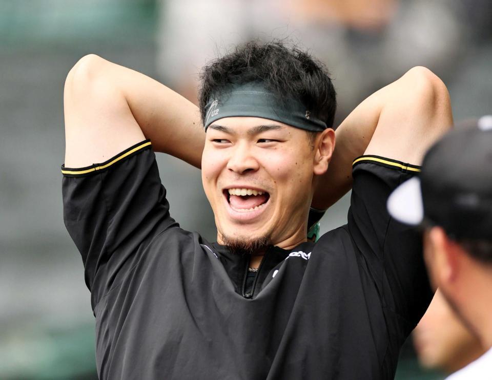 　打撃練習を待つ間、笑顔を見せる佐藤輝（撮影・田中太一）