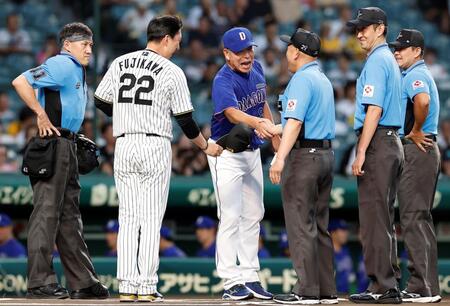 審判と力強く握手をする井上監督（撮影・西田忠信）