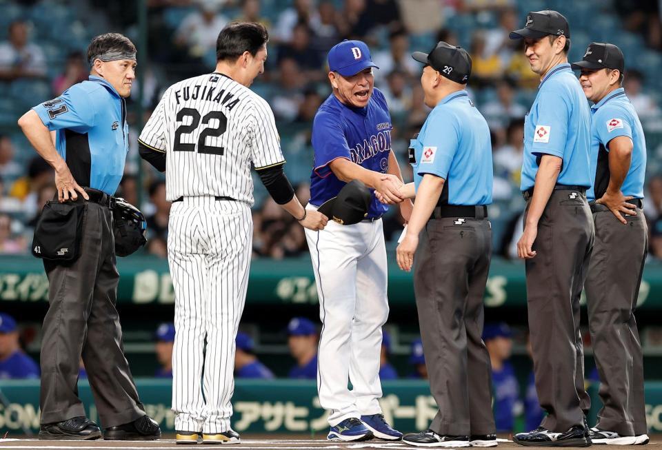 審判と力強く握手をする井上監督（撮影・西田忠信）