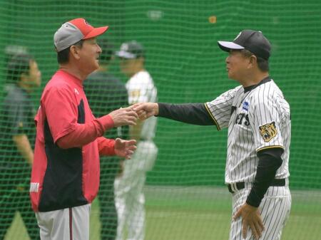 雨天中止になり室内練習場であいさつをかわす平田２軍監督（（右））と高２軍監督（撮影・金居みつよし）