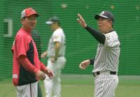 雨天中止になり室内練習場であいさつをかわす平田２軍監督（右）と高２軍監督（撮影・金居みつよし）