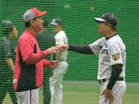 雨天中止になり室内練習場であいさつをかわす平田２軍監督（（右））と高２軍監督（撮影・金居みつよし）