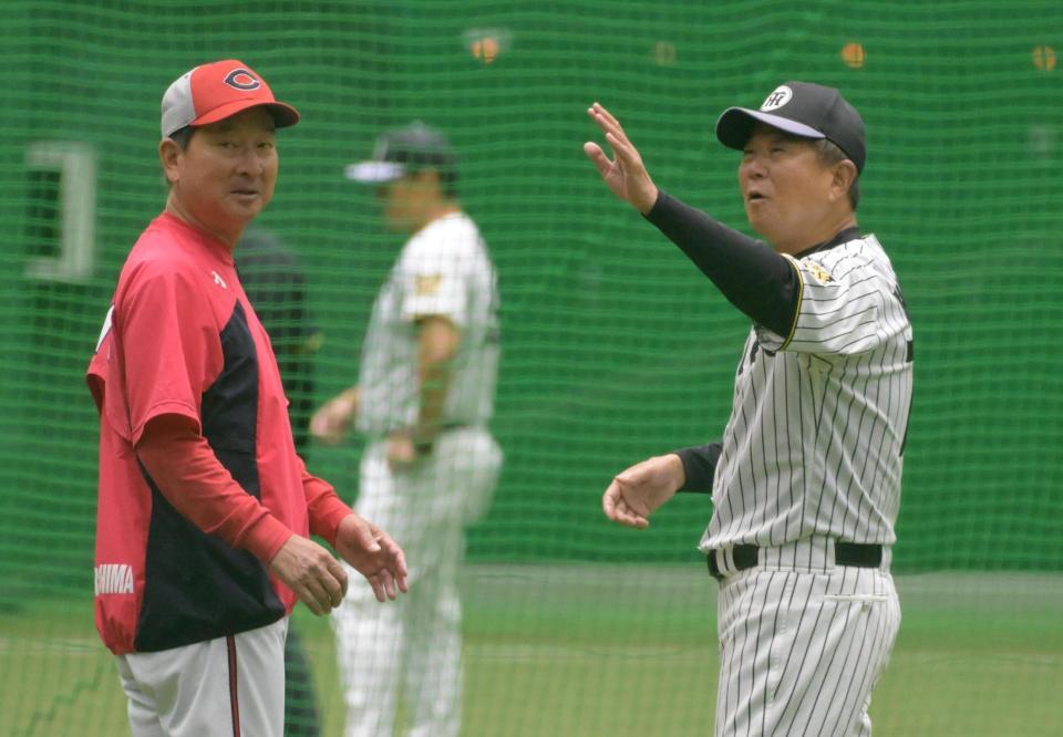 雨天中止になり室内練習場であいさつをかわす平田２軍監督（右）と高２軍監督（撮影・金居みつよし）