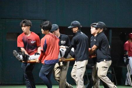 担架で運ばれる谷端