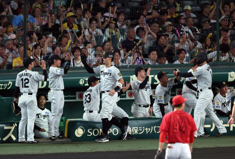 １回、大山の適時二塁打で生還しナインに迎えられる佐藤輝と森下（撮影・山口登）