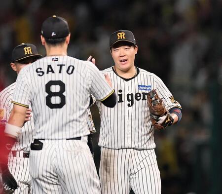 広島に連勝し、阪神・佐藤輝明とタッチを交わす阪神・大山悠輔＝甲子園（撮影・田中太一）