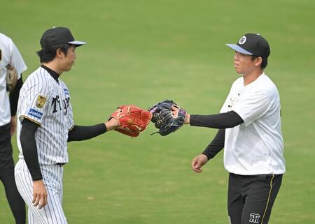 キャッチボールを終え、才木（左）とタッチを交わす村上（撮影・飯室逸平）