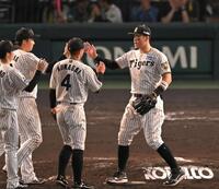勝利のハイタッチを交わす阪神・佐藤輝明（右）ら阪神ナイン＝甲子園（撮影・飯室逸平）