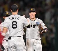 広島に連勝し、阪神・佐藤輝明とタッチを交わす阪神・大山悠輔＝甲子園（撮影・田中太一）