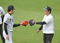 キャッチボールを終え、才木（左）とタッチを交わす村上（撮影・飯室逸平）