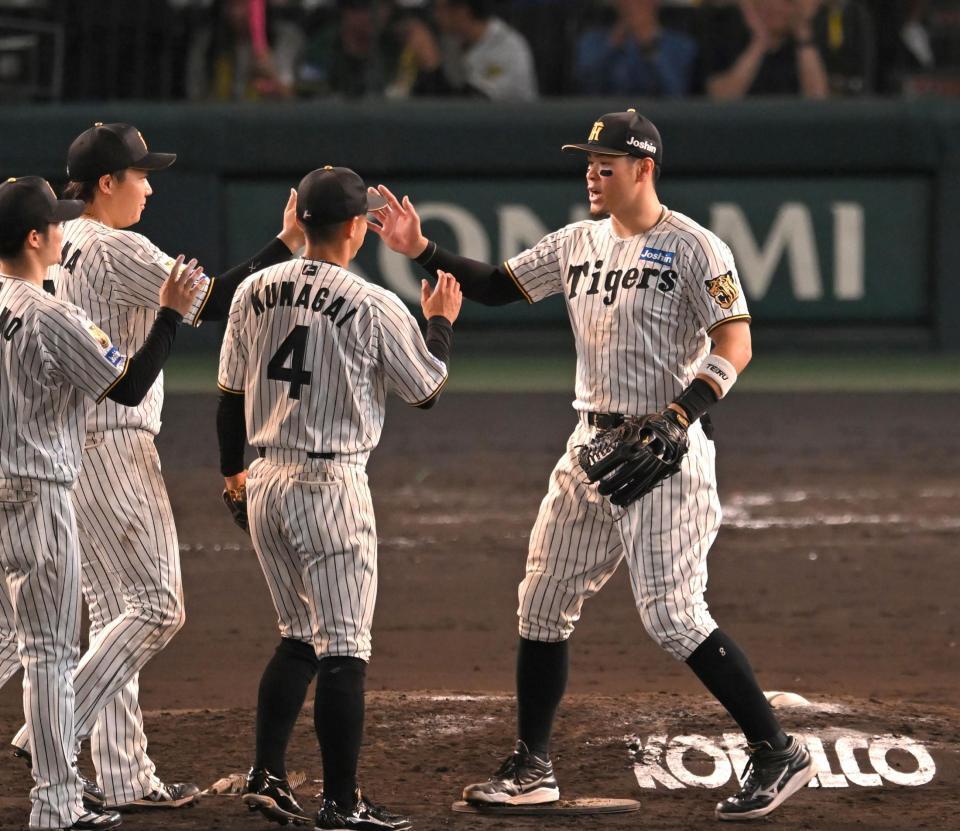 勝利のハイタッチを交わす阪神・佐藤輝明（右）ら阪神ナイン＝甲子園（撮影・飯室逸平）