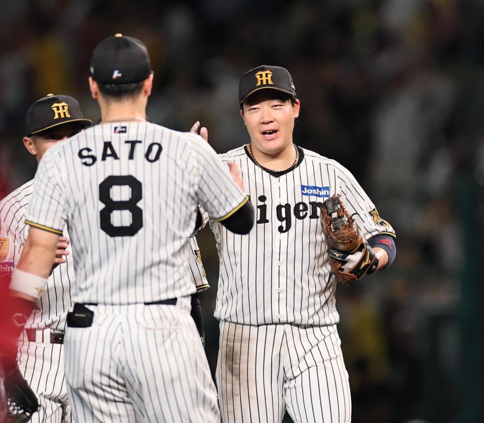 広島に連勝し、阪神・佐藤輝明とタッチを交わす阪神・大山悠輔＝甲子園（撮影・田中太一）