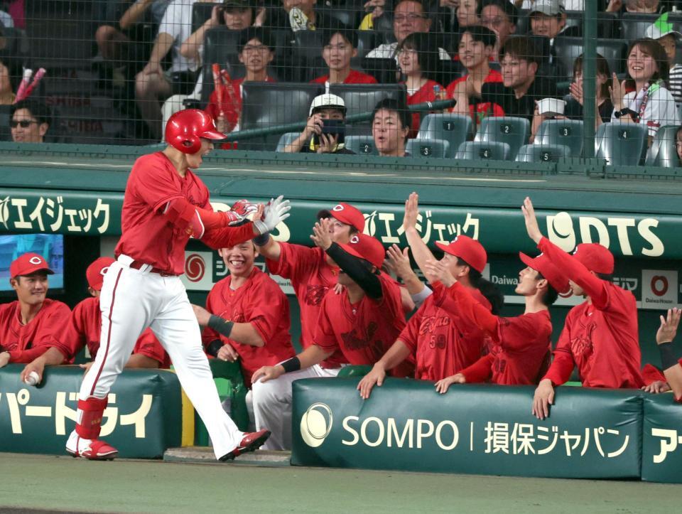 １回、先制ソロを放ちナインに迎えられる佐藤啓（撮影・山口登）