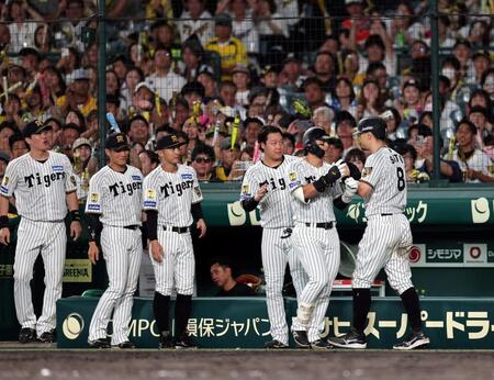 ５回。前川の犠飛で生還しナインに迎えられる佐藤輝（撮影・山口登）