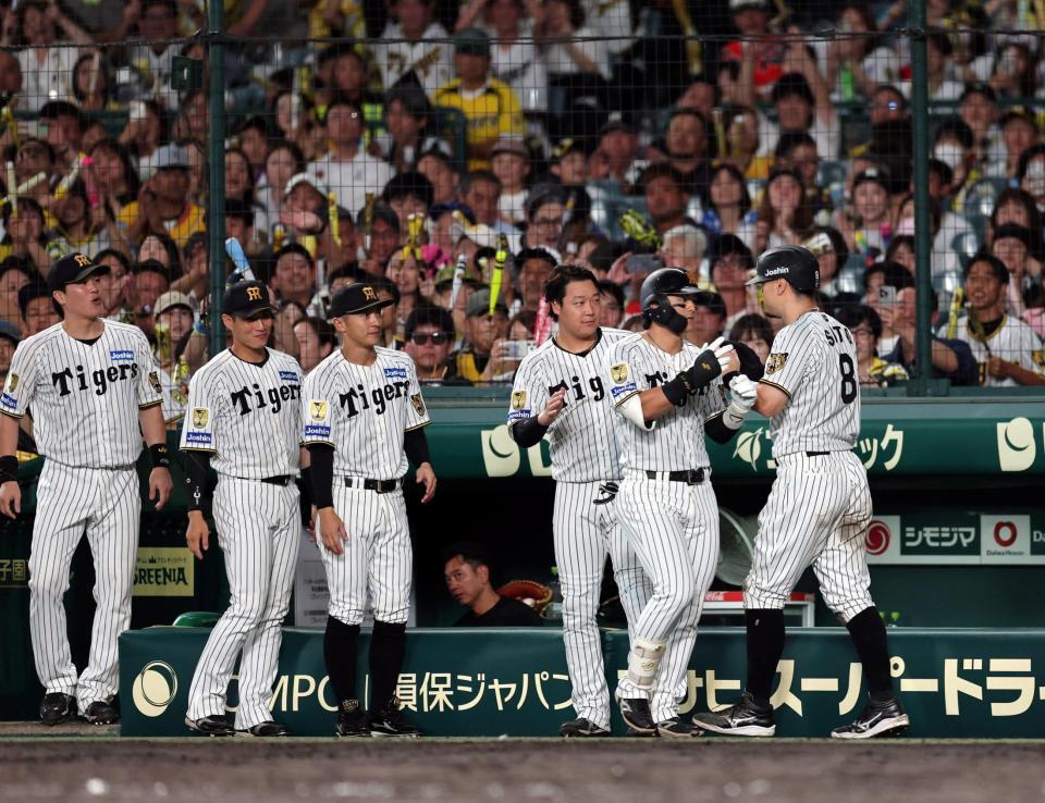 ５回。前川の犠飛で生還しナインに迎えられる佐藤輝（撮影・山口登）