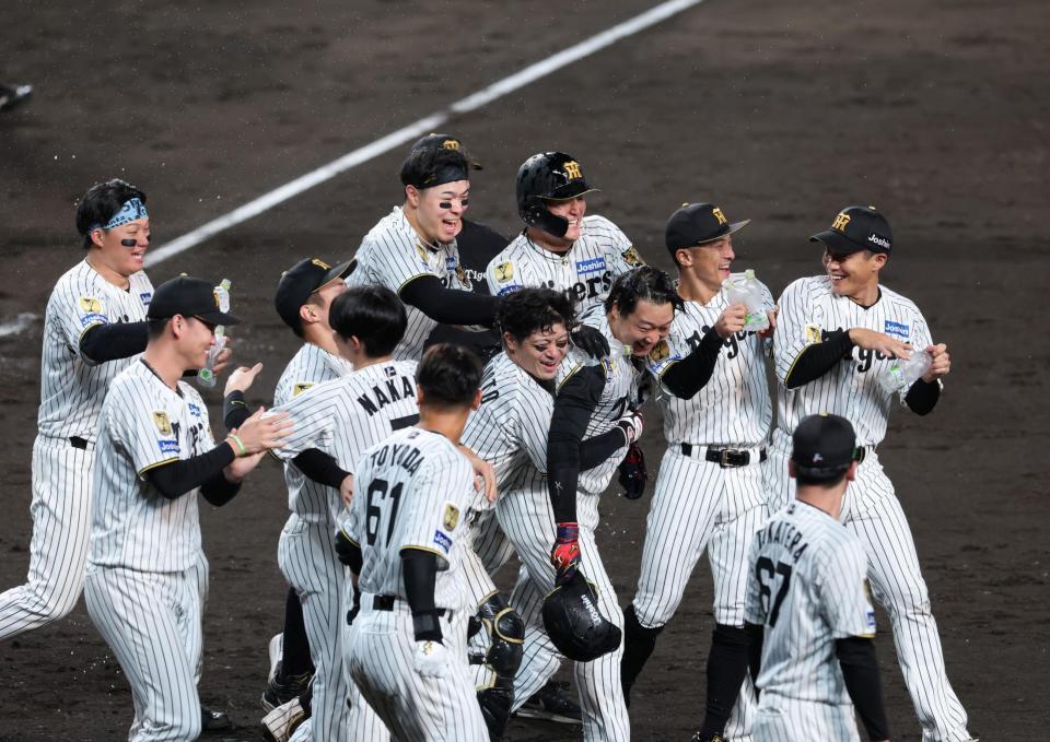 １１回阪神１死、阪神・大山悠輔はサヨナラソロを放ち生還しナインから祝福を受ける＝甲子園（撮影・山口登）