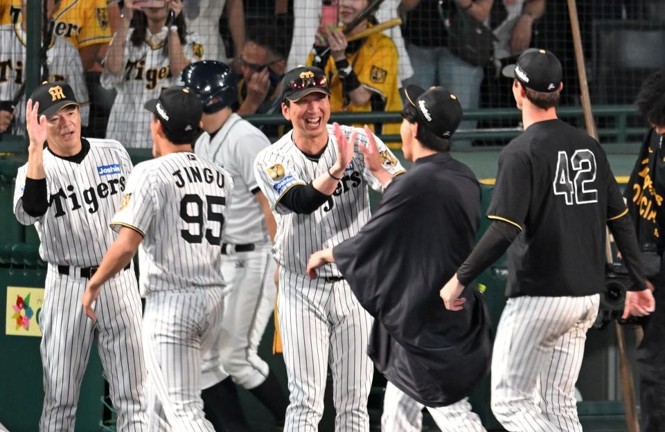 笑顔でハイタッチを交わす藤川監督（撮影・飯室逸平）