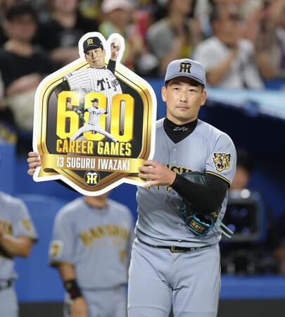 通算６００試合登板を達成し、ボードを持つ岩崎（撮影・西岡正）
