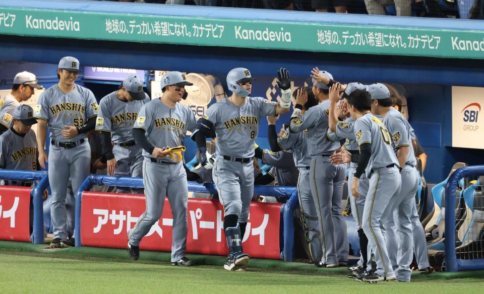 １回、右越えに２ランを放ちナインに迎えられる佐藤輝（撮影・金田祐二）
