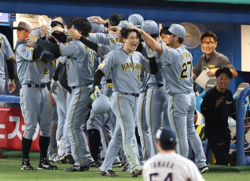 延長１１回、勝ち越し２ランを放ちナインに迎えられる高寺（撮影・金田祐二）