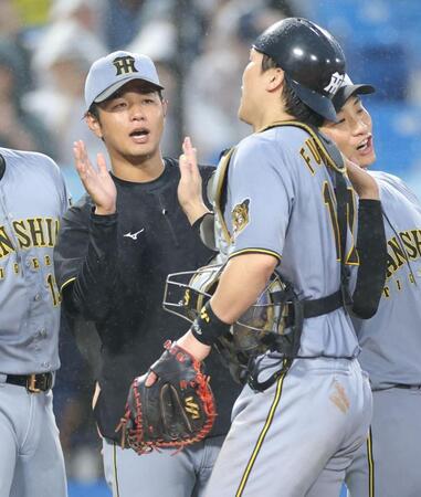 １５勝目を挙げ、伏見（右）とタッチを交わす高橋（撮影・西岡正）