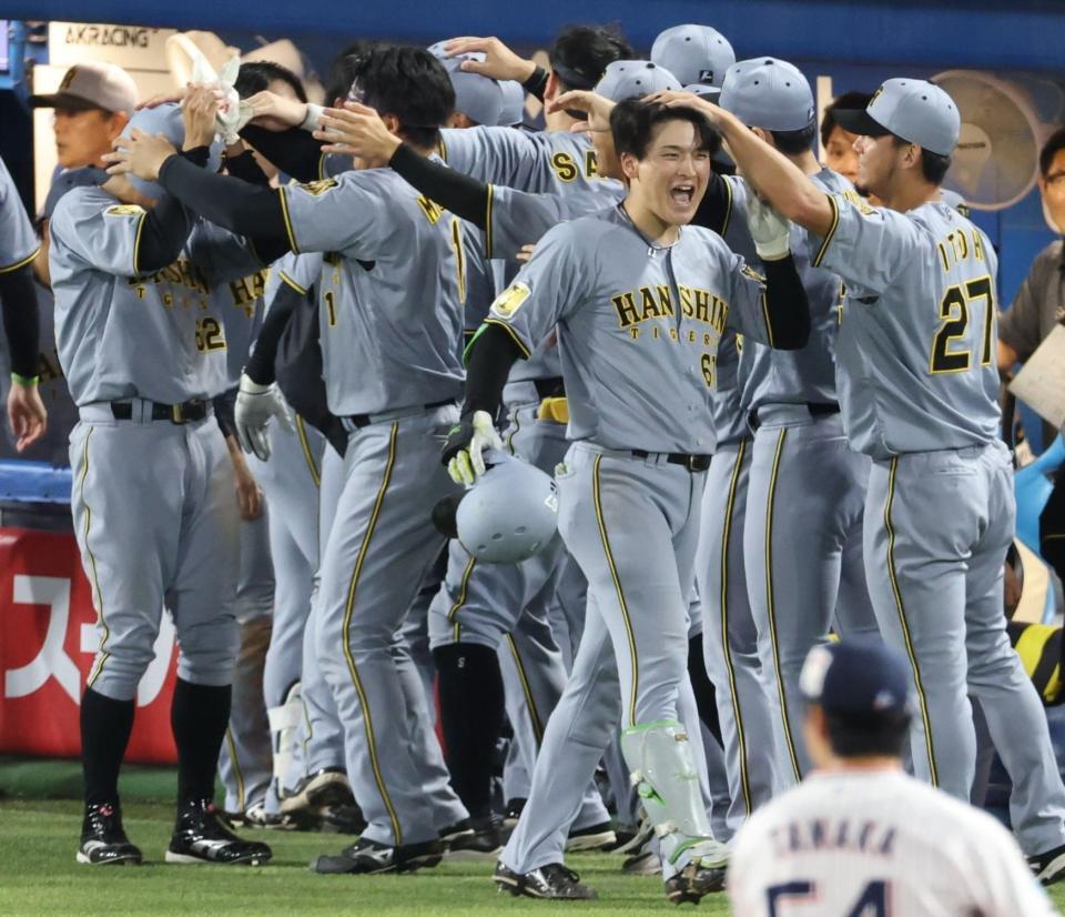 延長１１回、勝ち越し２ランを放ちナインに迎えられる高寺（撮影・金田祐二）