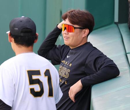 練習前、早川（左）と談笑する西勇（撮影・山口登）