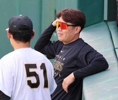 　練習前、早川（左）と談笑する西勇