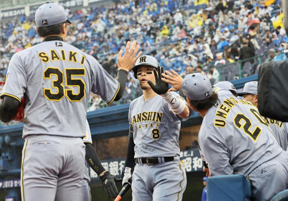 １回、先制犠飛を放った佐藤輝は才木とタッチを交わす（撮影・田中太一）