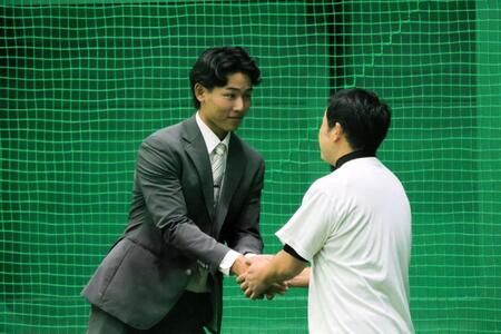 仲野トレーナー（右）と握手を交わす戸井