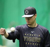 右腕でボールを転がす佐藤輝（撮影・西田忠信）