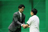 仲野トレーナー（右）と握手を交わす戸井