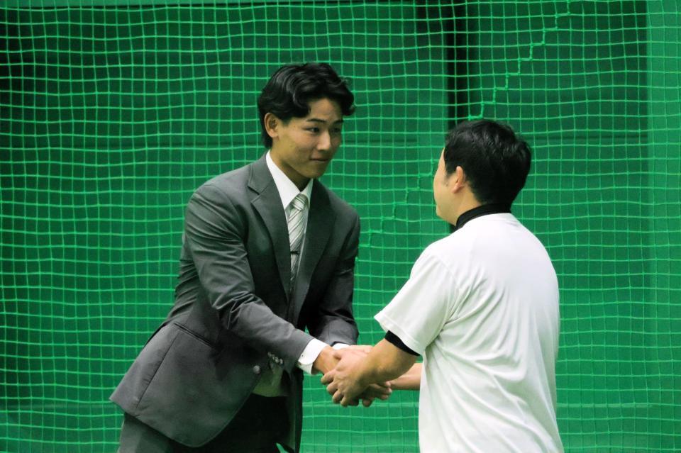 仲野トレーナー（右）と握手を交わす戸井