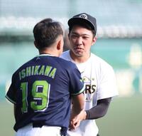 石川と握手をする石井（撮影・西田忠信）