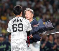 今季限りで引退する石川は石井（左）から花束を受け取る（撮影・西田忠信）