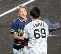 石井（６９）から花束を受け取る石川（撮影・立川洋一郎）