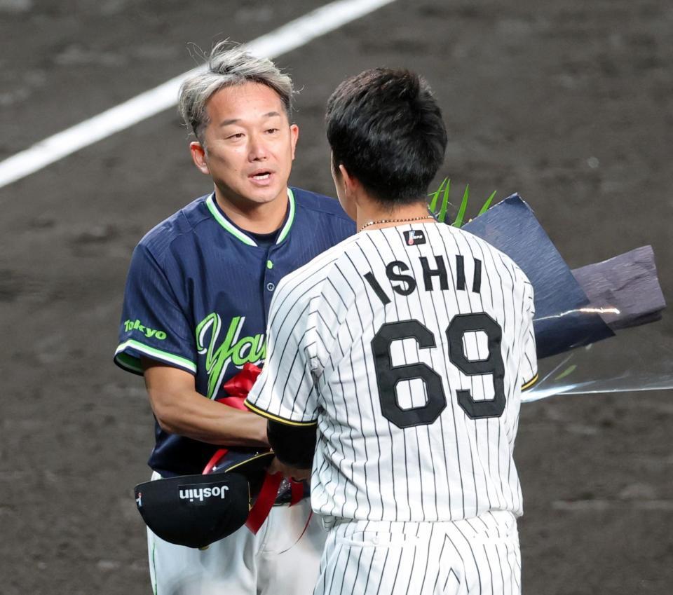 石井（６９）から花束を受け取る石川（撮影・立川洋一郎）