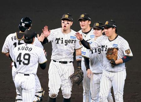 　勝利のタッチを交わす佐藤輝（中央左）ら阪神ナイン（撮影・立川洋一郎）