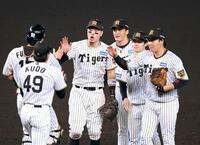 勝利のタッチを交わす佐藤輝（中央左）ら阪神ナイン（撮影・立川洋一郎）