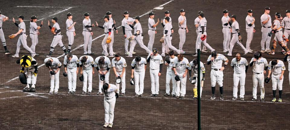 １２回を戦い終えて引き分け。スタンドのファンにあいさつする阪神ナイン（手前）＝撮影・立川洋一郎