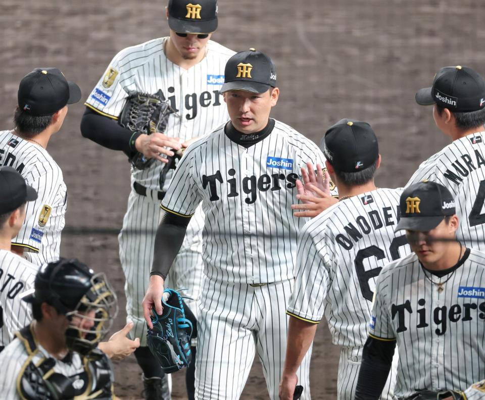 １１回を無失点に抑えナインとタッチを交わす岩崎（撮影・立川洋一郎）