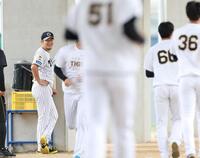 笑顔で練習を見つめる岩貞（左）＝撮影・西田忠信