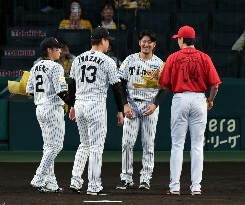 岩貞（中央右）は梅野、岩崎、大瀬良から花束を贈られる（撮影・山口登）