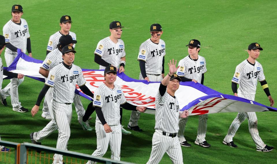 優勝ペナントを手にグラウンド一周する佐藤輝（中央左）と森下（中央右）ら阪神ナイン（撮影・山口登）