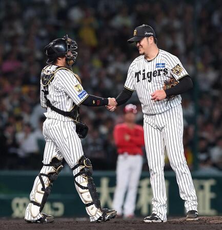　登板を終え、梅野（左）と握手する岩貞（撮影・西田忠信）
