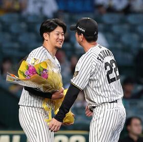 藤川監督（右）から花束を受け取る岩貞（撮影・西田忠信）