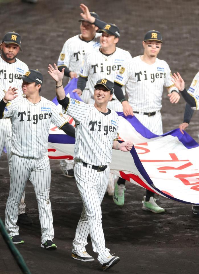 リーグ優勝のペナントを手に場内を回り、ファンの歓声に応える藤川監督（中央）ら（撮影・立川洋一郎）